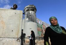 Palestinian women wait at Qalandiya checkpoint under Israeli occupation.